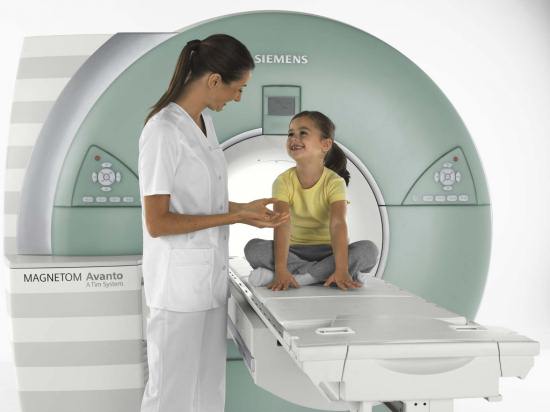 Лаборант успокаивает ребенка перед магнитно-резонансной томографией