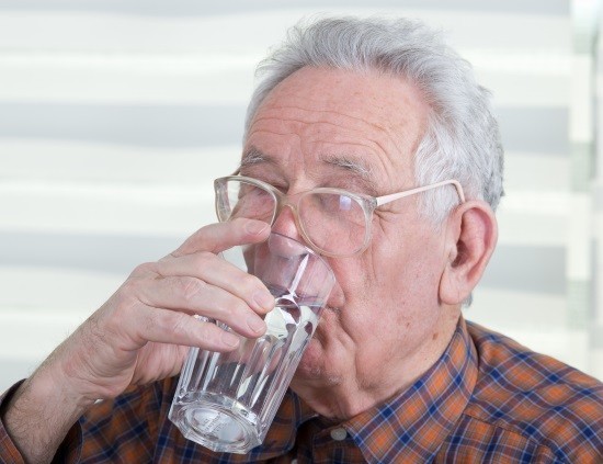 Мужчина пьет минеральную воду